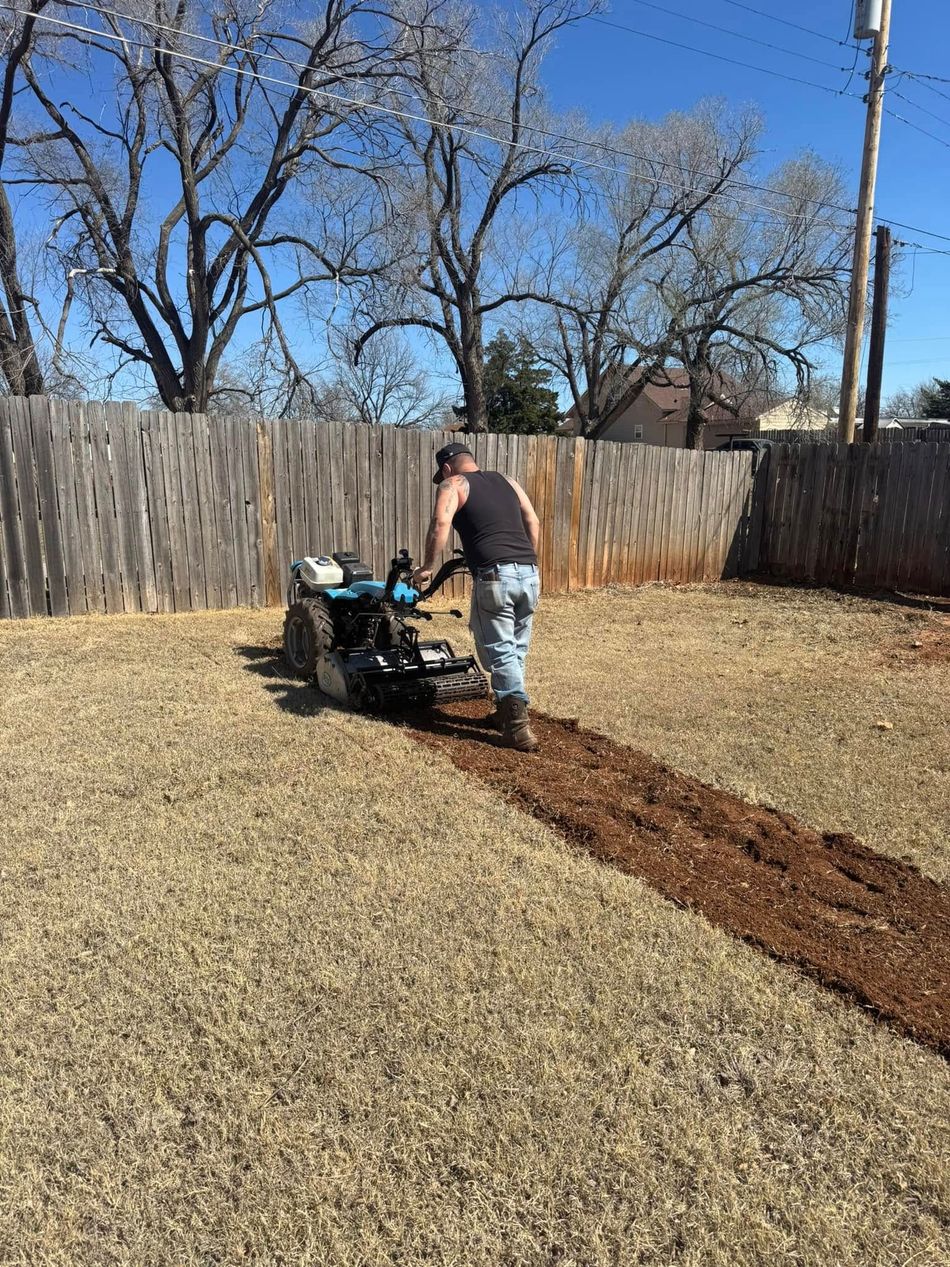A man is using a machine to dig a hole in the ground.