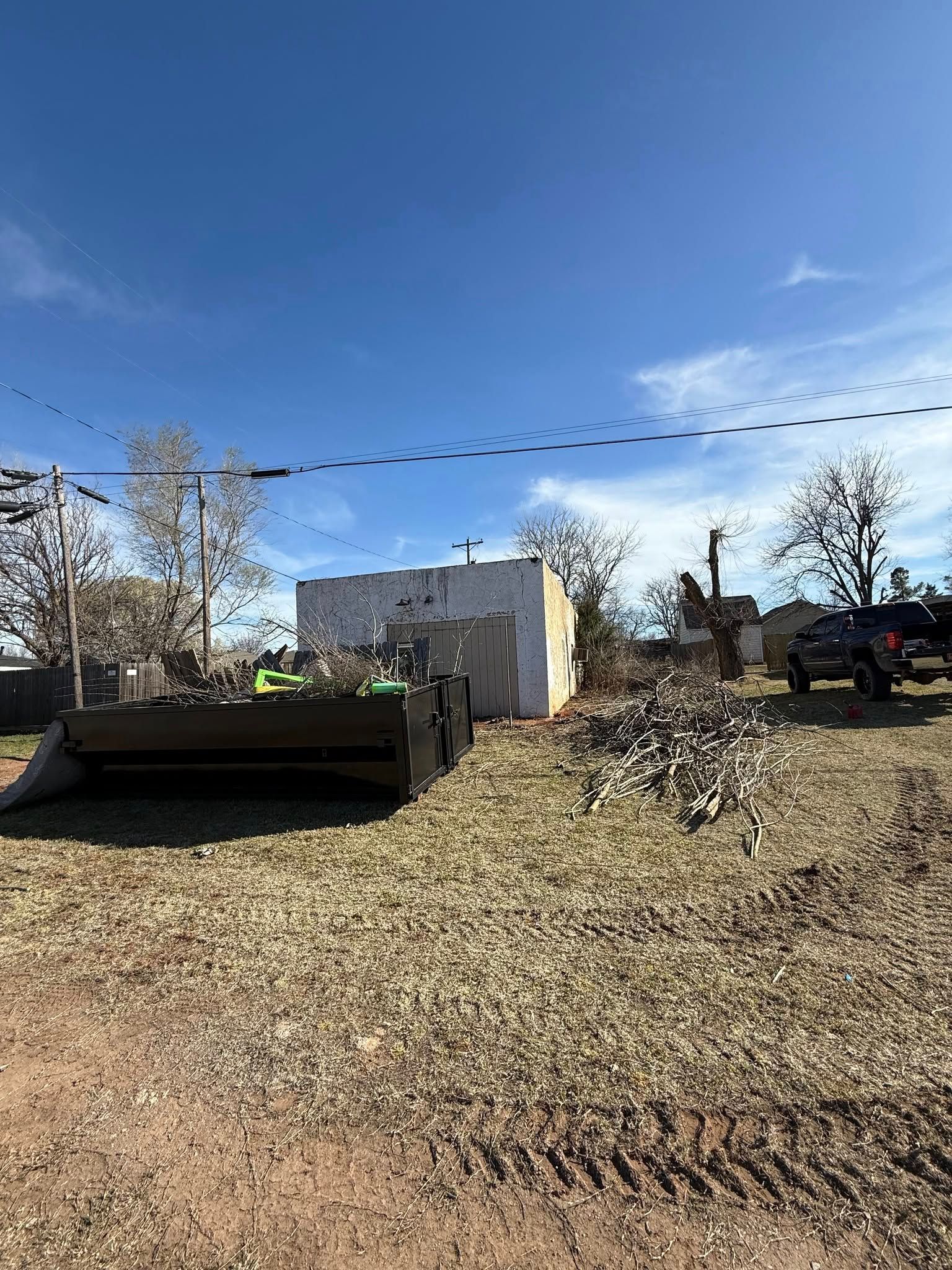 A bulldozer is parked in a dirt field in front of a building.