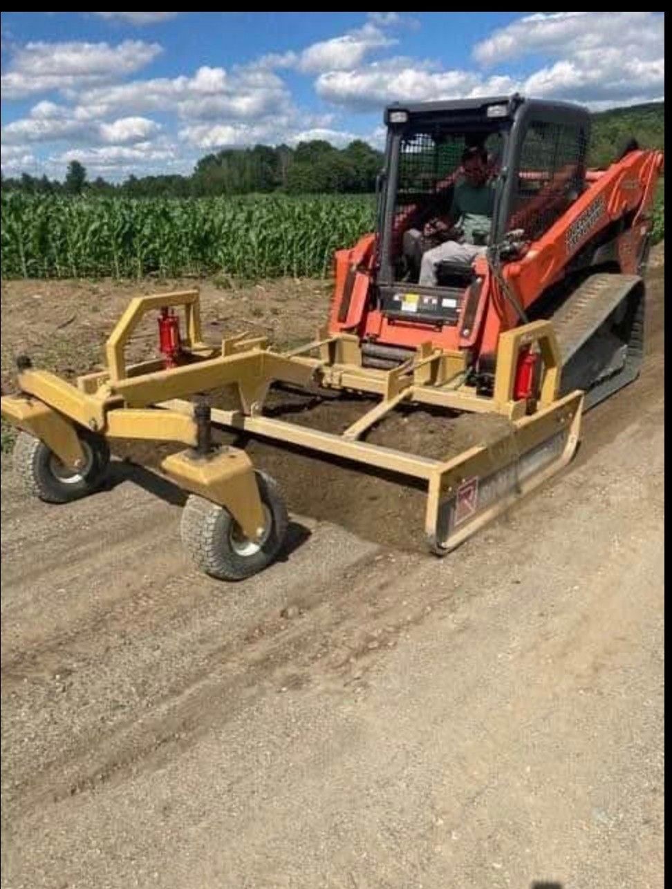A man is driving a bulldozer on a dirt road.