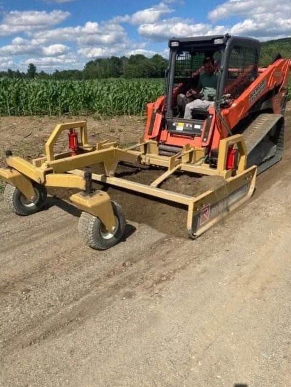 A man is driving a bulldozer on a dirt road.