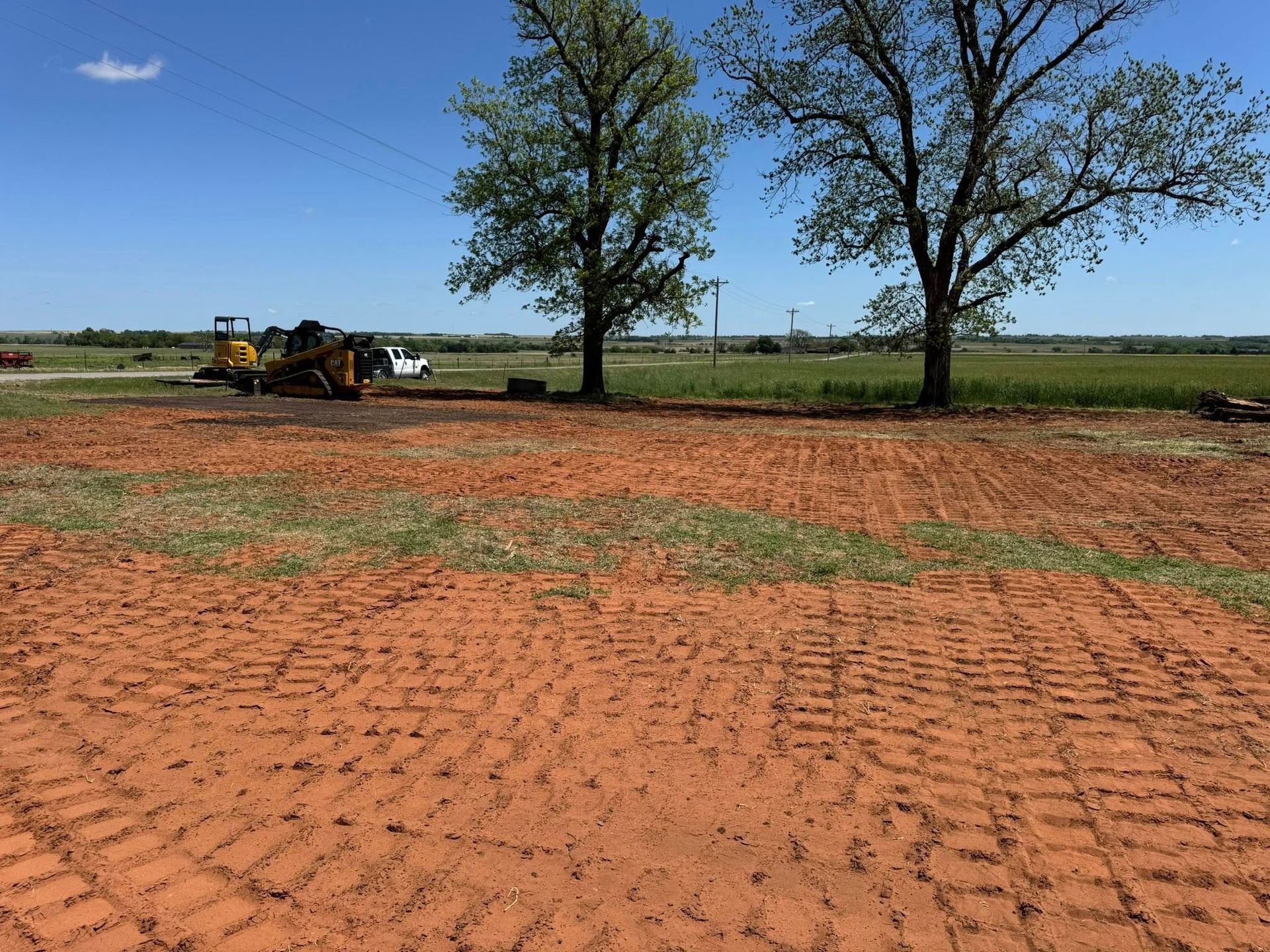 A large dirt field with trees in the background