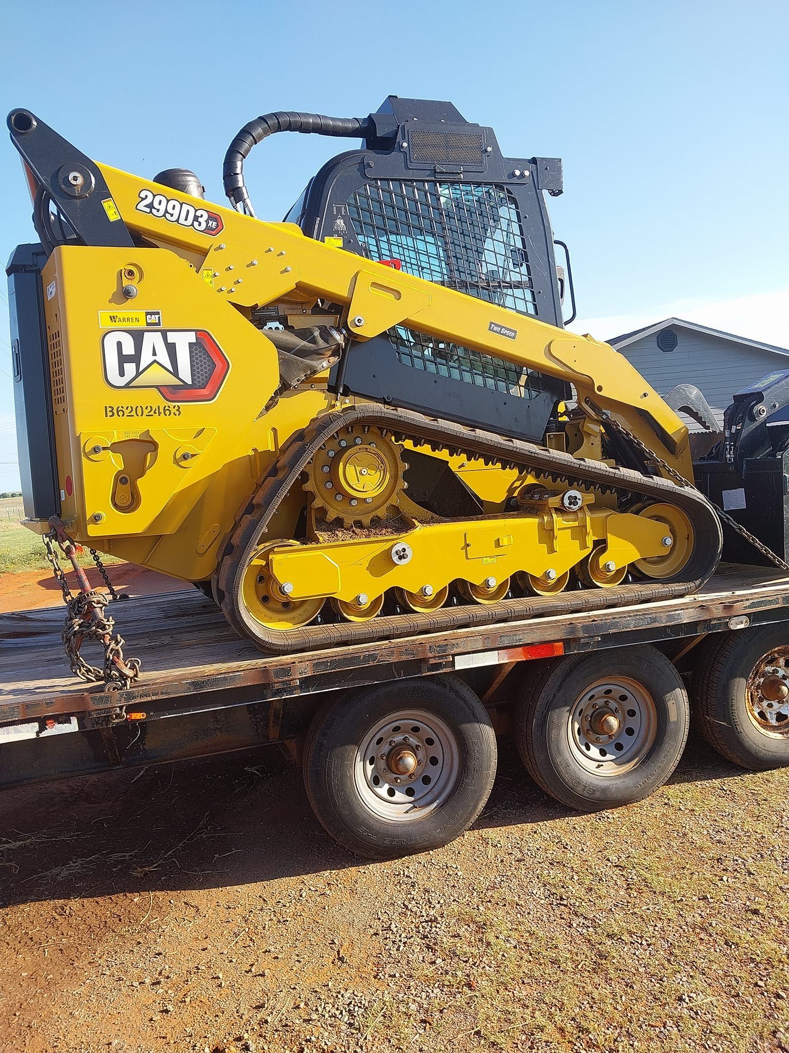 A yellow cat bulldozer is sitting on top of a trailer.