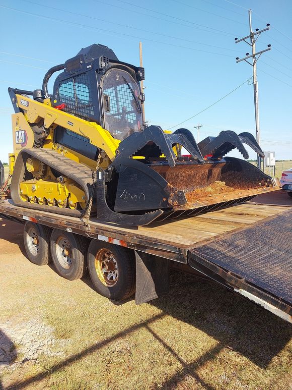 A bulldozer is sitting on top of a flatbed truck.