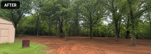 A backyard with a wooden fence and dirt in the middle of it.
