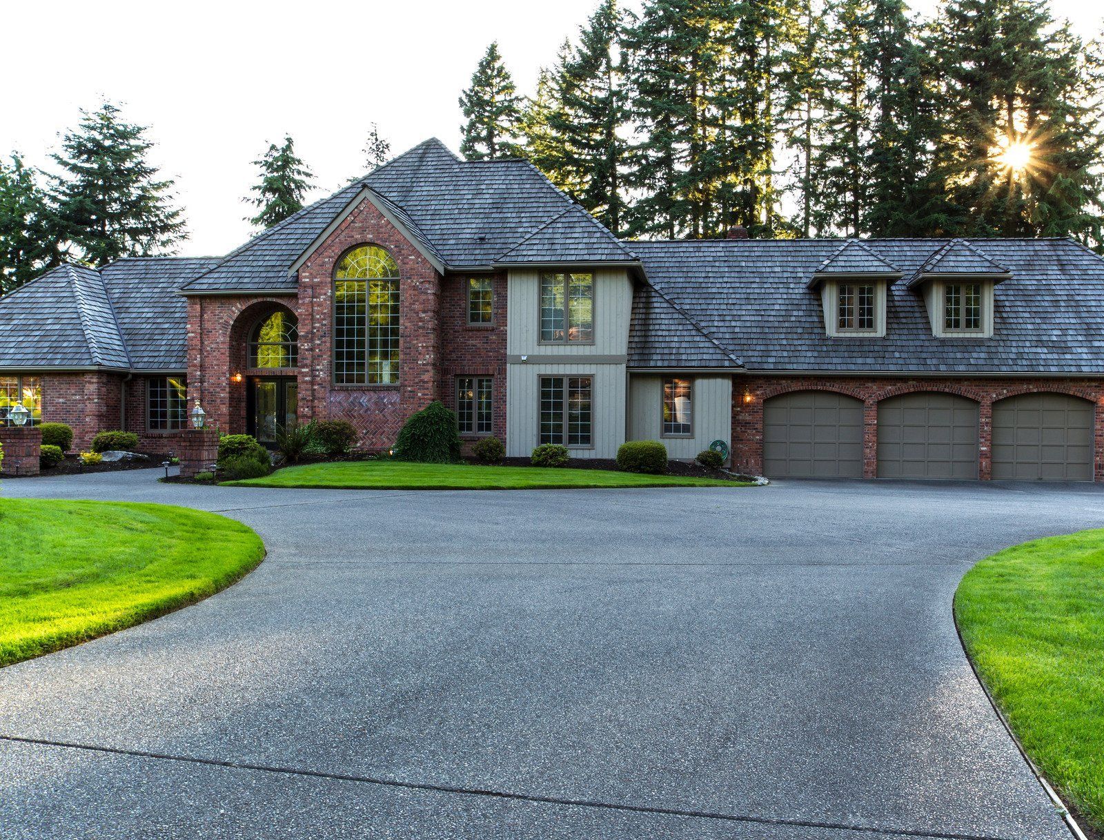 A large brick house with a driveway leading to it