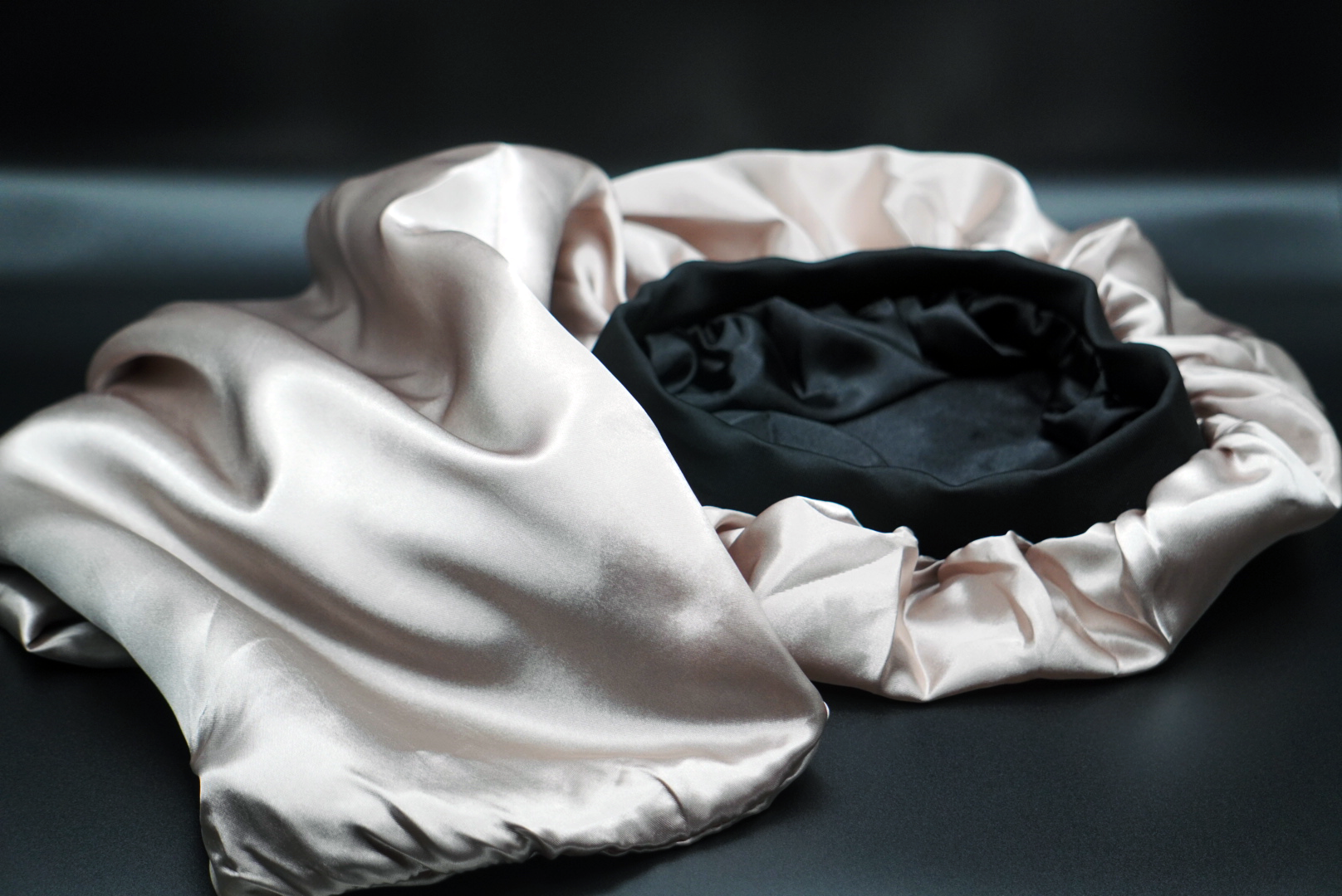 Oversized satin bonnet in Ebony Cream, designed for long or thick hair, shown flat with reversible lining