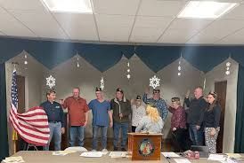 A group of people are standing around a table with an american flag.