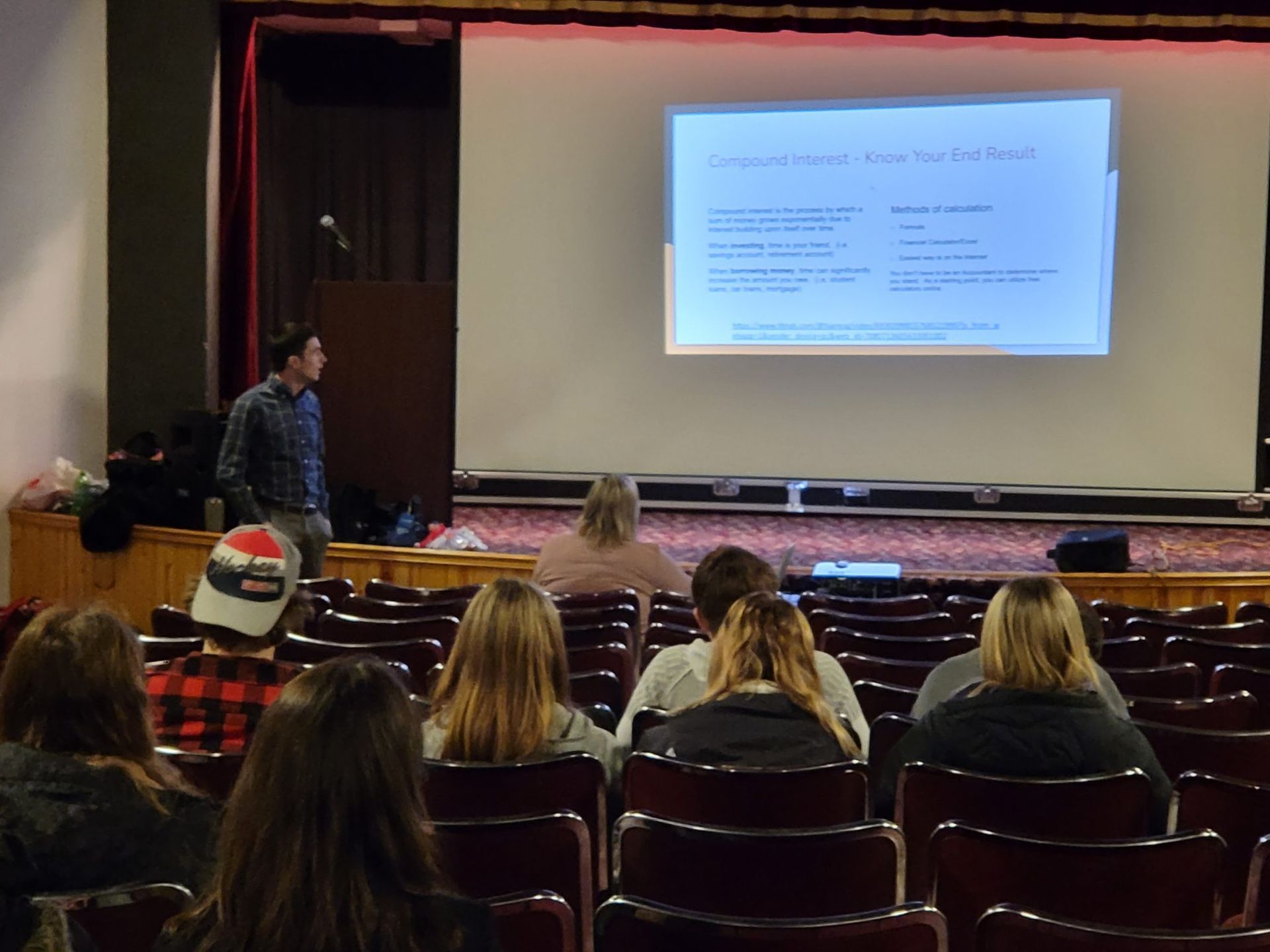 A man is giving a presentation to a group of people in an auditorium