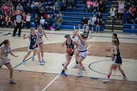 A group of girls are playing basketball on a court.