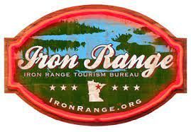 A sign for iron range tourism bureau with a moose on it.