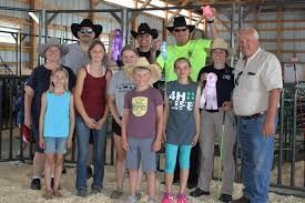 A group of people are posing for a picture in a barn.