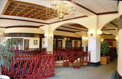 A hotel lobby with a red railing and a chandelier