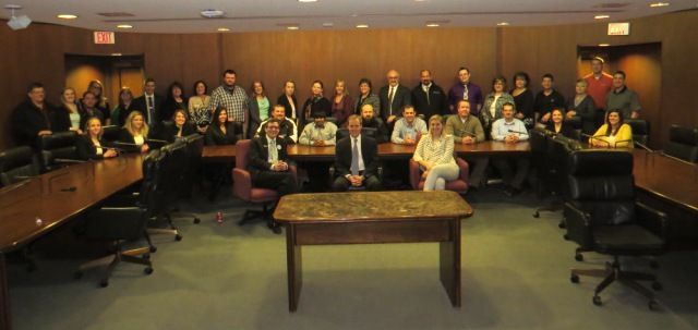 A group of people are posing for a picture in a conference room