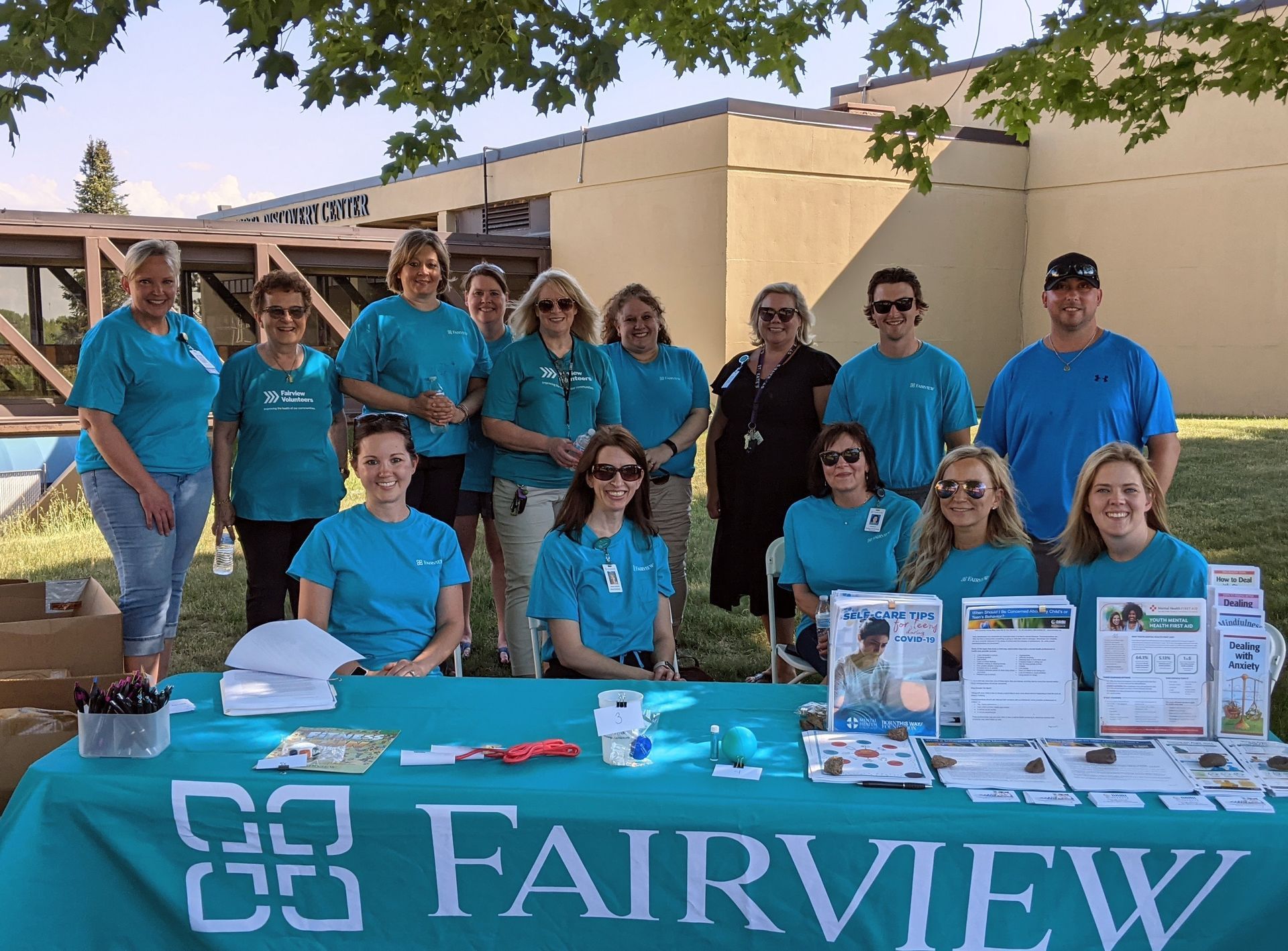 A group of people standing around a table that says fairview