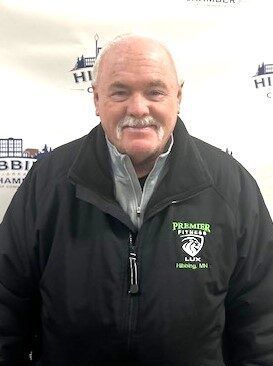 A man with a mustache is wearing a black jacket.