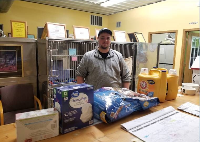 A man is standing in front of a table with a bag of diapers on it