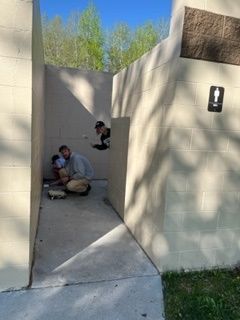 A group of people are kneeling in a public restroom.