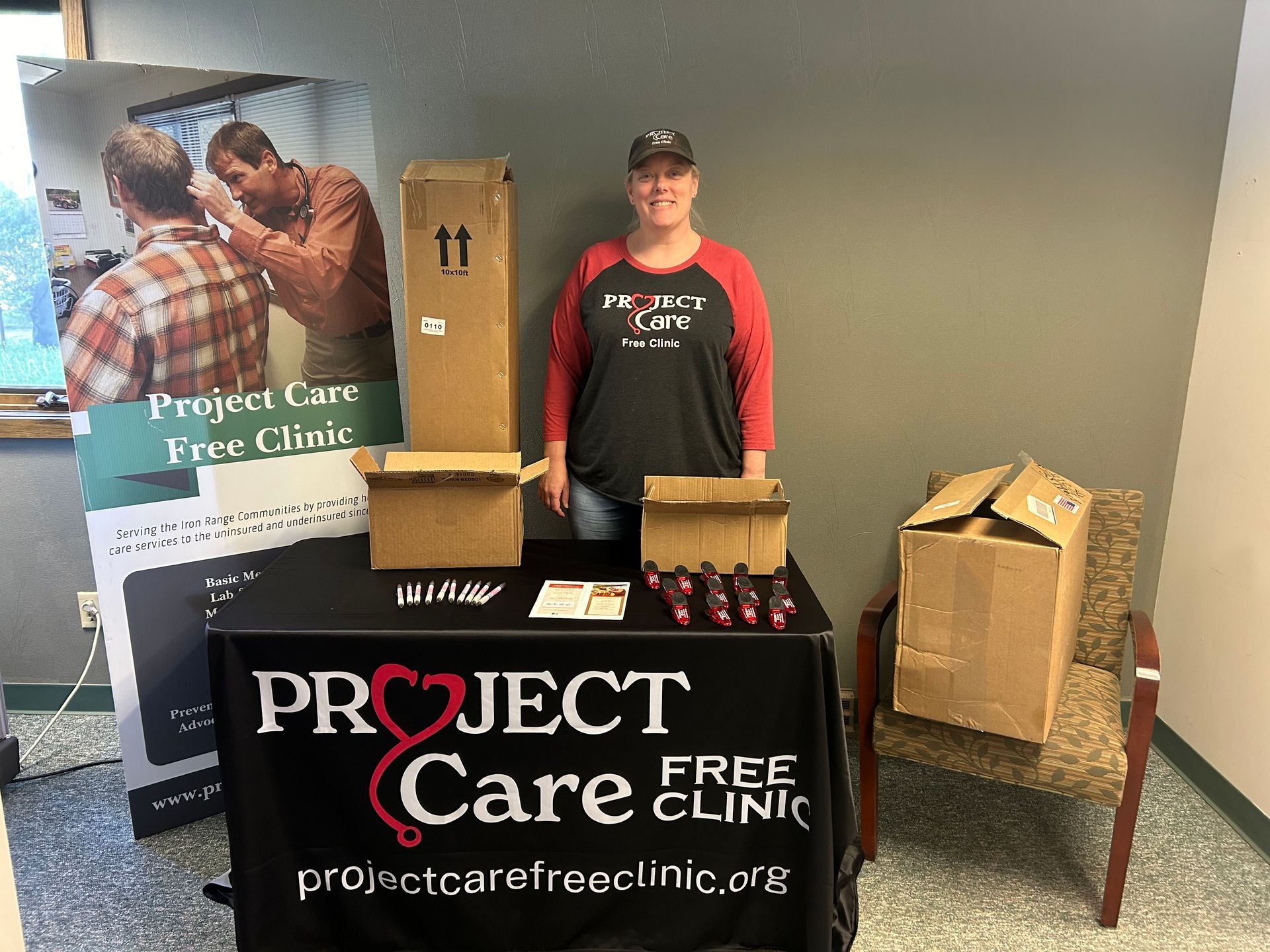 A woman is standing in front of a project care free clinic table