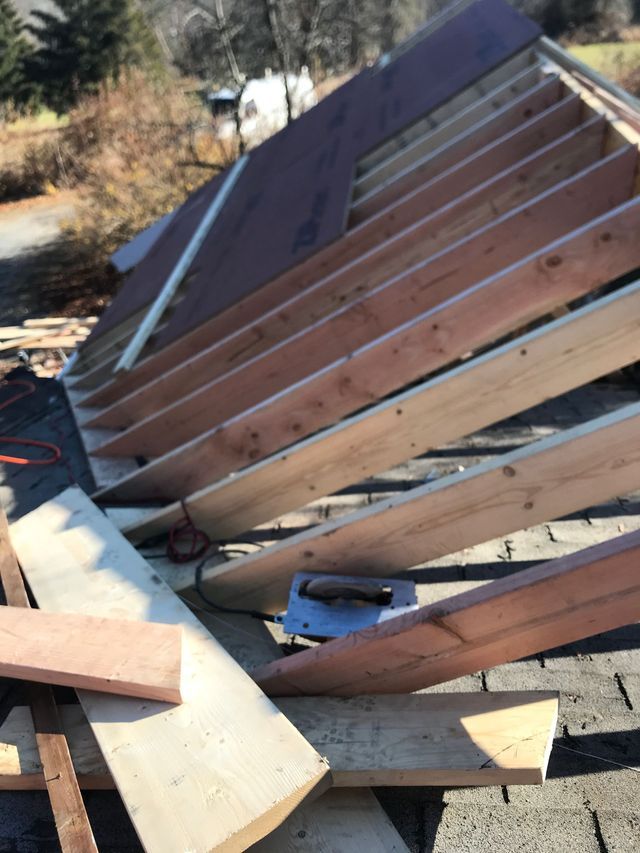 A wooden structure is being built on a brick roof