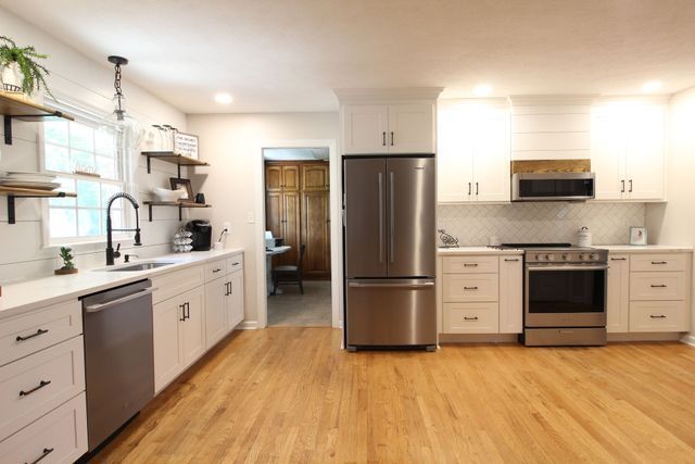 A kitchen with stainless steel appliances and white cabinets