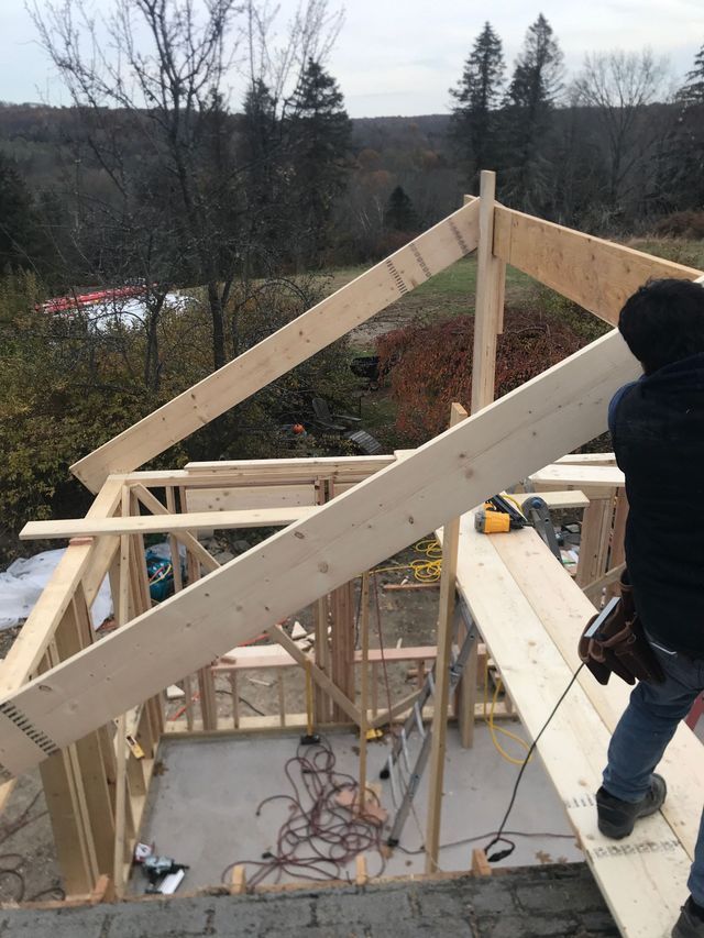 A man is standing on top of a wooden structure.