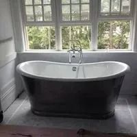 A bathtub is sitting in a bathroom next to a window.