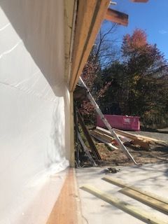 A building under construction with a pink dumpster in the background.