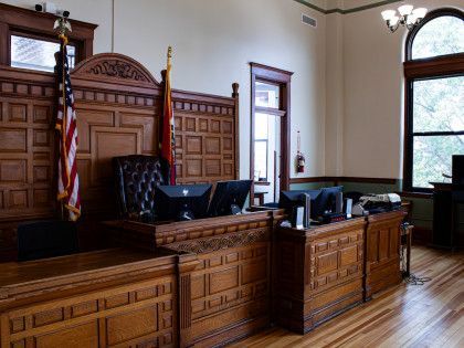 a courtroom with wooden benches , chairs , and computers .
