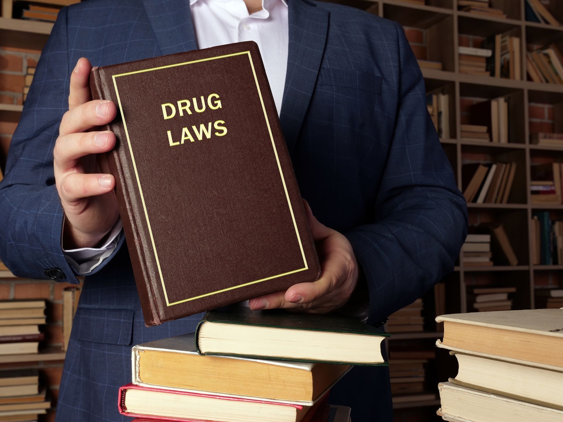 a man in a suit is holding a book titled drug laws .