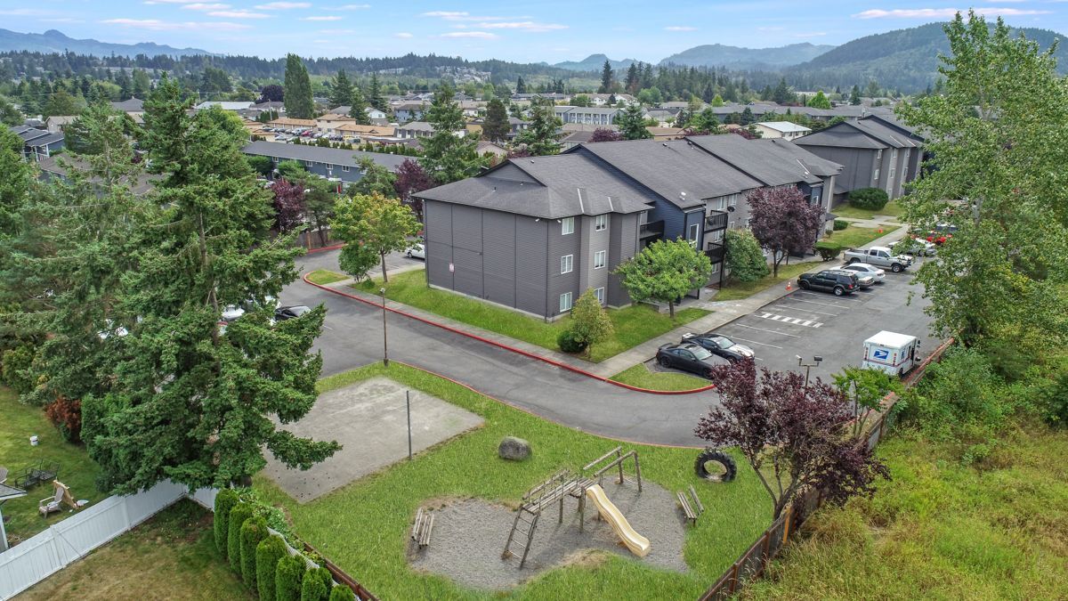 An aerial view of a apartment complex with a playground in front of it.