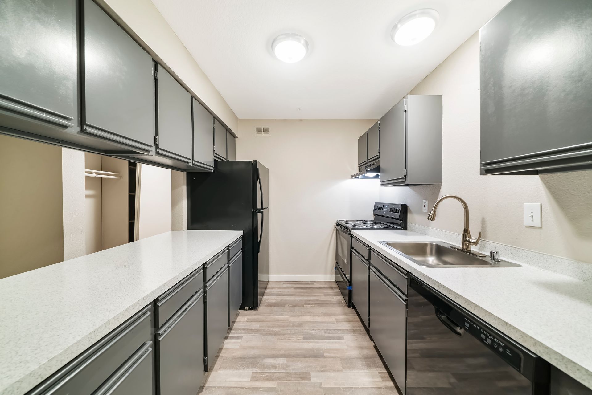 A kitchen with gray cabinets and stainless steel appliances