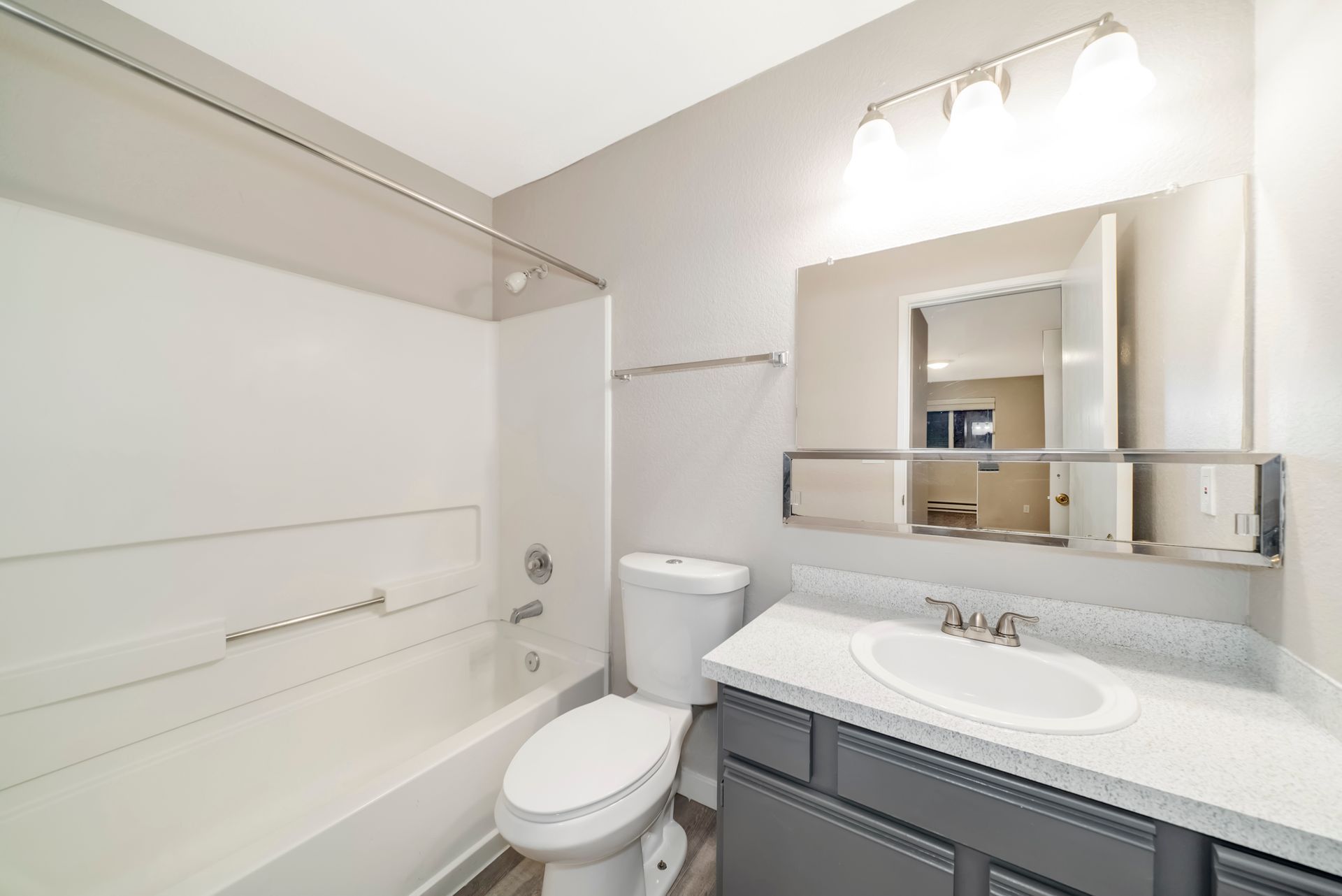 A bathroom with a toilet , sink , and bathtub.