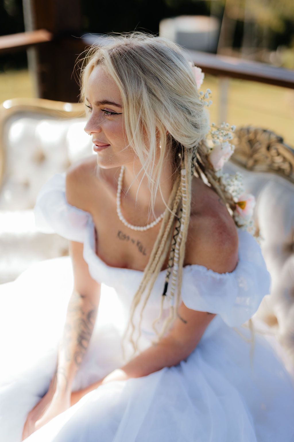 A Woman in a White Dress is Sitting on a Couch — Prim n Proper Event Hire in Palmview, QLD