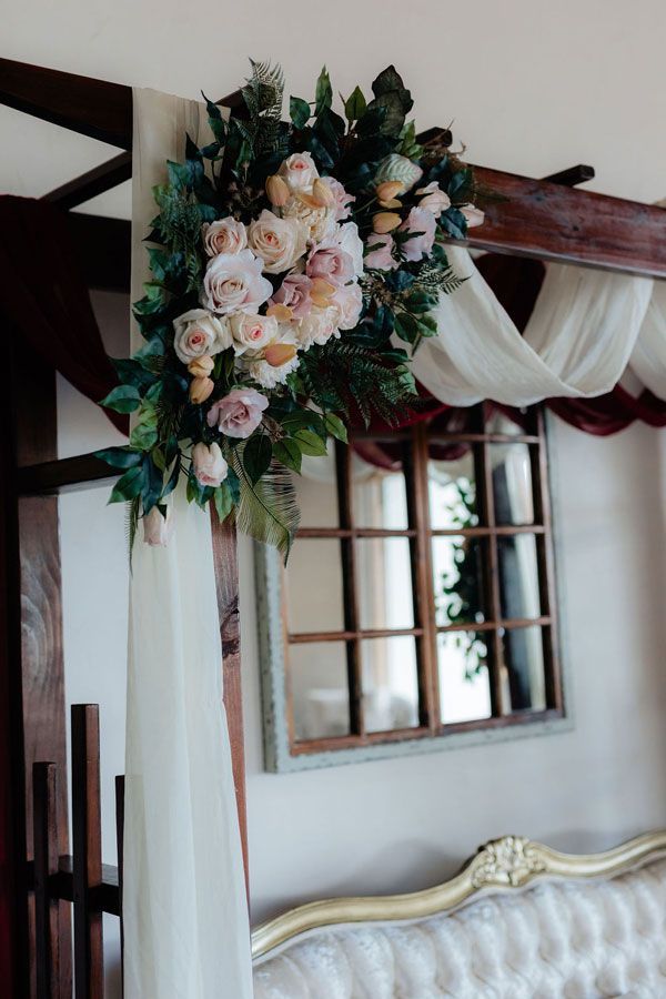 A Bed With a Canopy and Flowers on It in a Room — Prim n Proper Event Hire in Palmview, QLD