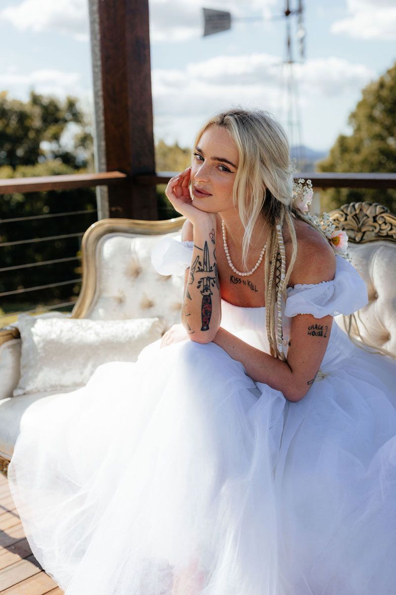 A Woman in a White Dress is Sitting on a Couch — Prim n Proper Event Hire in Palmview, QLD