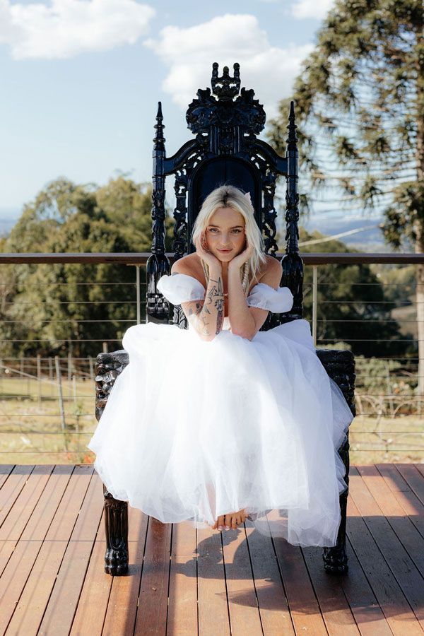 A Woman in a White Dress is Sitting on a Black Throne — Prim n Proper Event Hire in Palmview, QLD