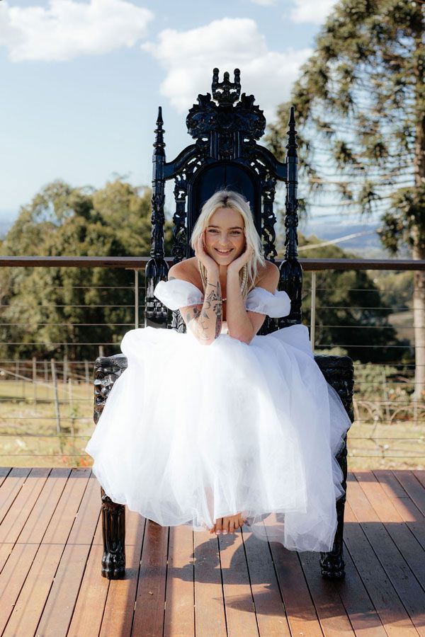 A Woman in a White Dress is Sitting on a Black Throne — Prim n Proper Event Hire in Palmview, QLD