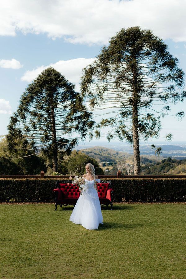 A Bride in a White Dress is Holding a Bouquet of Flowers — Prim n Proper Event Hire in Palmview, QLD
