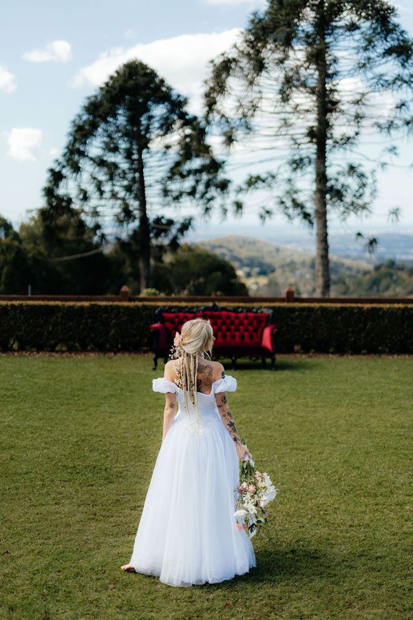 A Bride in a White Dress is Holding a Bouquet of Flowers — Prim n Proper Event Hire in Palmview, QLD