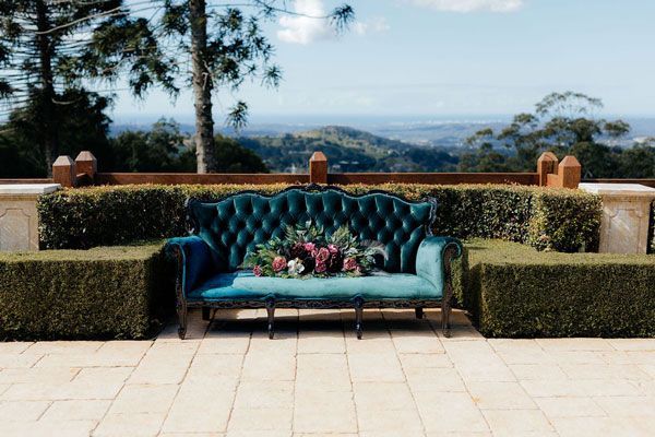 A Blue Couch With Flowers on It is Sitting on a Patio — Prim n Proper Event Hire in Palmview, QLD