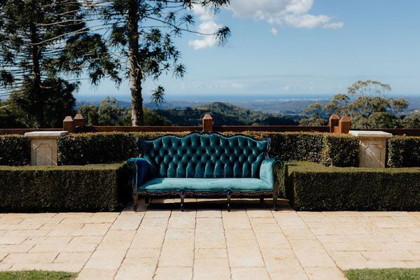 A Blue Couch is Sitting on a Patio With a View of the Mountains — Prim n Proper Event Hire in Palmview, QLD