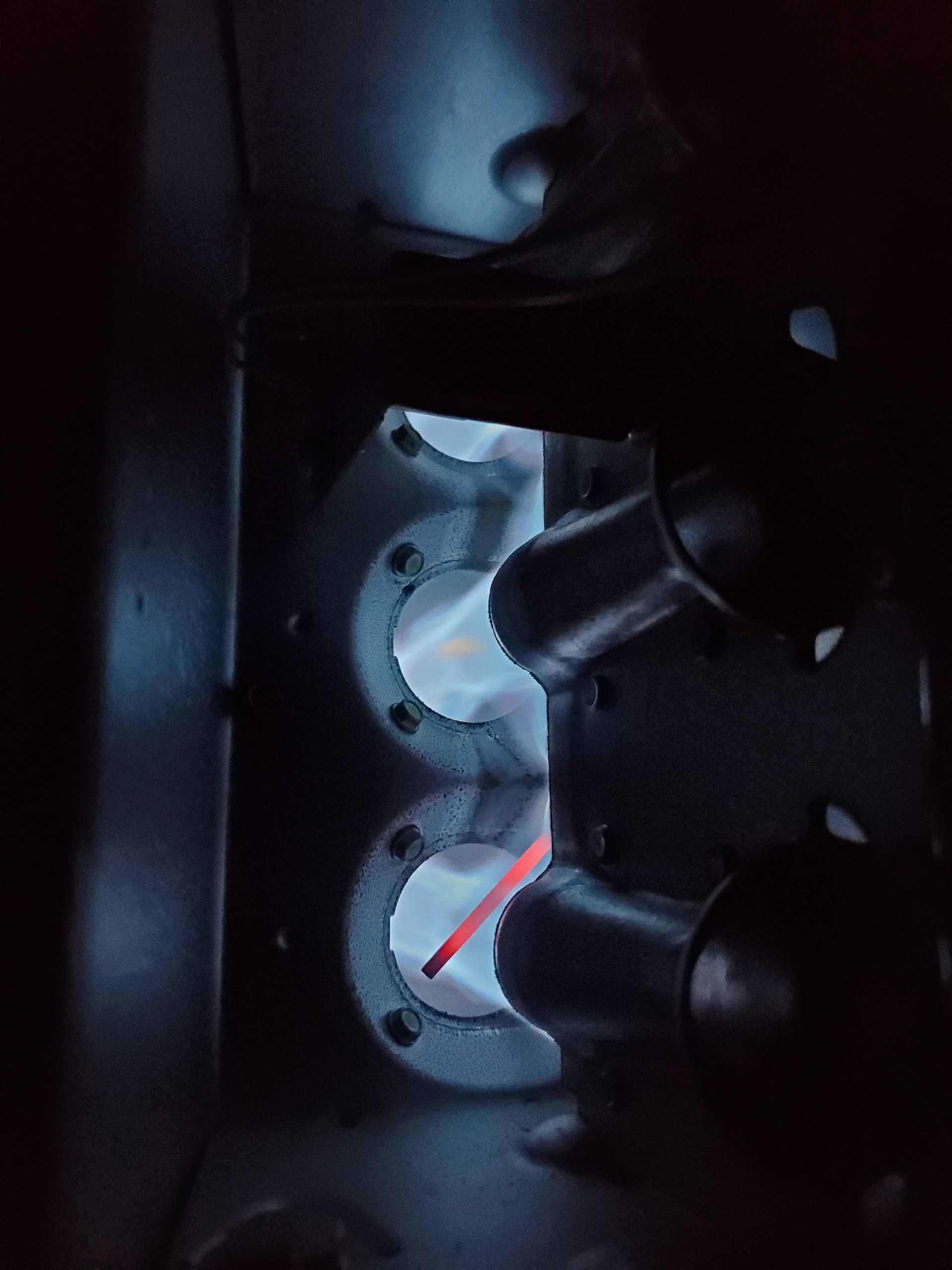 Blue flames visible inside a furnace, with a red glowing metal component.