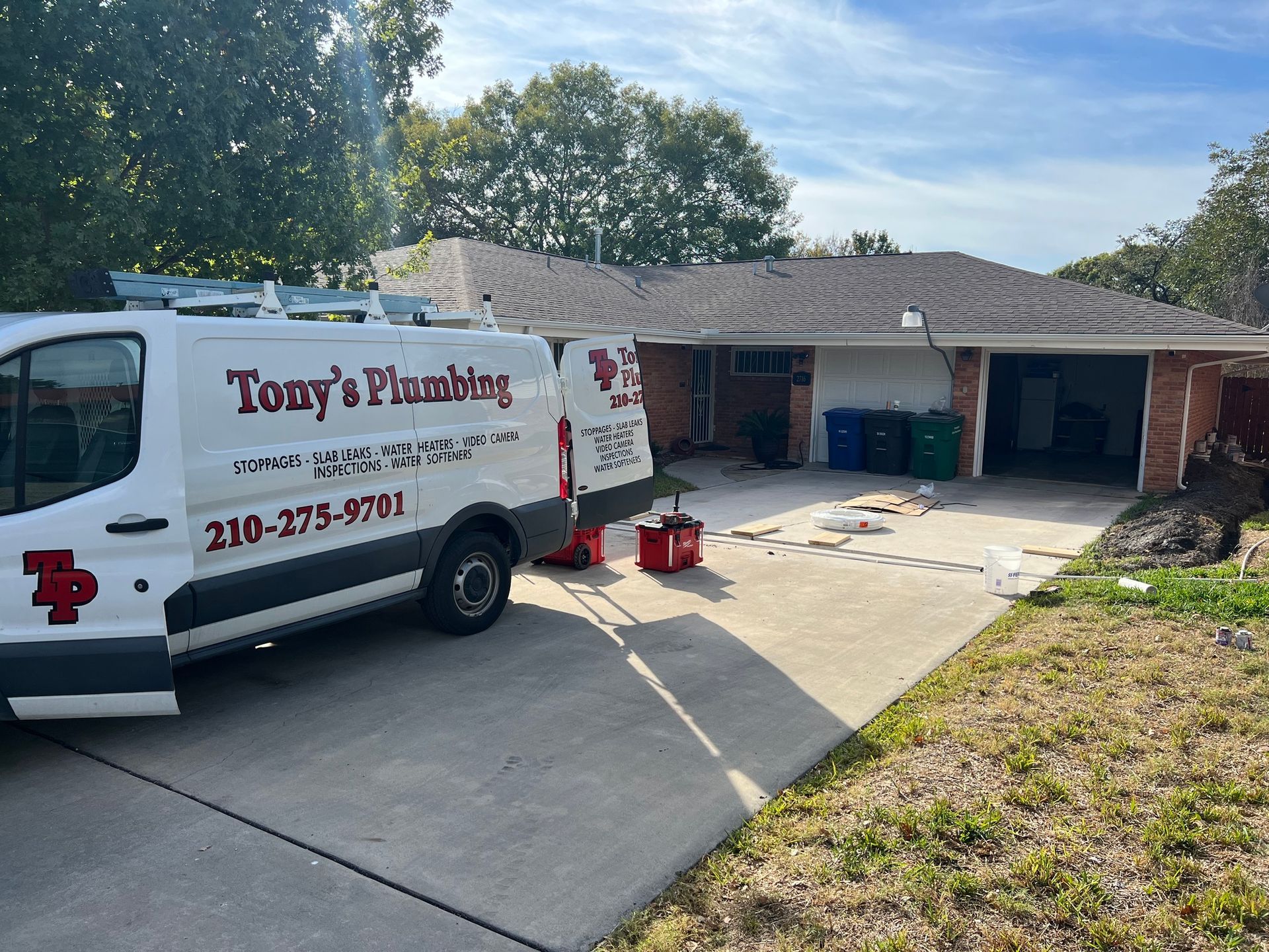 A tony 's plumbing van is parked in front of a house