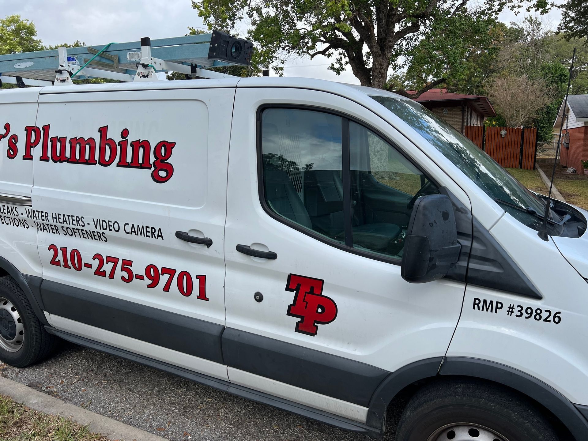A plumbing van is parked on the side of the road.