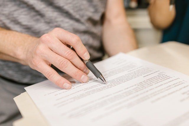 Close up of a person reviewing a legal document with a pen