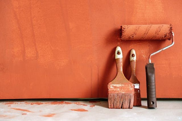 paint brushes against orange wall