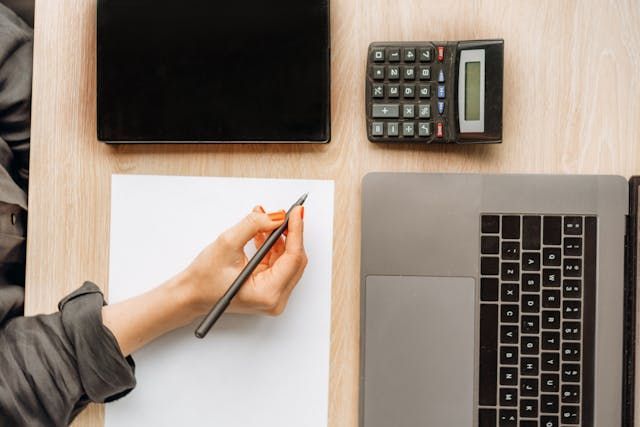 person with calculator and laptop
