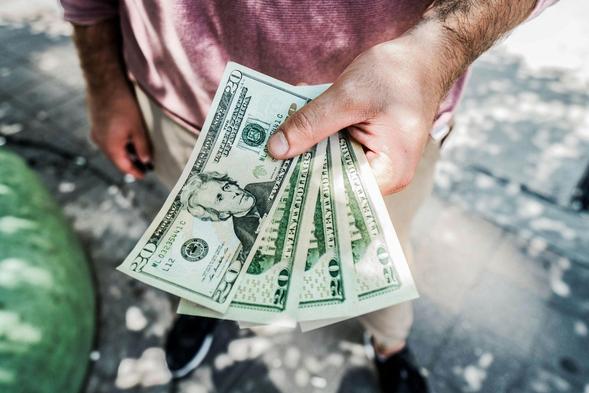 person holding several twenty-dollar bills
