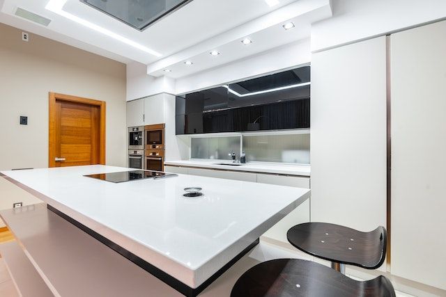 White kitchen with a counter and bright LED lights