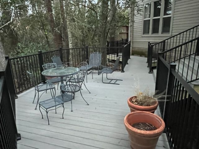 A deck with a table and chairs and potted plants